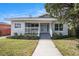 Charming single-story home featuring a welcoming front porch and well-manicured lawn at 104 W South Ave, Tampa, FL 33603