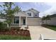 Inviting two-story home featuring stone accents, a two-car garage, and beautifully landscaped front yard at 11884 Richmond Trl, Parrish, FL 34219