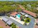 Aerial view of community pool surrounded by lush landscaping and neighboring homes at 1201 Montrose Pl, Dunedin, FL 34698