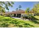This backyard features a patio, lush lawn, and views of mature trees at 1201 Montrose Pl, Dunedin, FL 34698