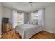 Comfortable bedroom with wood floors, neutral tones, and two sunny windows at 1201 Montrose Pl, Dunedin, FL 34698