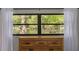 Bedroom window with view of a serene lake and lush green trees at 1201 Montrose Pl, Dunedin, FL 34698