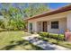 Charming villa exterior with lush landscaping and a view of the pond at 1201 Montrose Pl, Dunedin, FL 34698