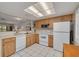 Well-lit kitchen features tile floors, white appliances, and ample cabinet space at 1201 Montrose Pl, Dunedin, FL 34698