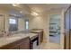 Bathroom with double vanity, granite countertops, and a walk-in shower beyond the doorways at 12421 Triple Creek Blvd, Riverview, FL 33579