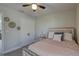 Neutral bedroom shows bed with light pink cover and a nightstand, ceiling fan, carpet, and white trim at 12421 Triple Creek Blvd, Riverview, FL 33579