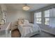 Bedroom featuring white wood bedframe, plush pillows, chandelier, and natural light from windows at 12421 Triple Creek Blvd, Riverview, FL 33579