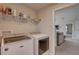 Laundry room with washer, dryer, and overhead shelving providing ample storage space at 12421 Triple Creek Blvd, Riverview, FL 33579