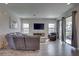 Inviting living room with a comfortable sectional couch, wood-look floors, and a large sliding glass door at 12421 Triple Creek Blvd, Riverview, FL 33579