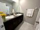 Bathroom featuring double sinks, granite counters, dark cabinets, and modern fixtures at 12957 Wildflower Meadow Dr, Riverview, FL 33579