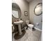 Chic powder room featuring a pedestal sink, a round mirror, and tile flooring at 12957 Wildflower Meadow Dr, Riverview, FL 33579