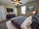 This bedroom features a ceiling fan, TV, modern dresser, and a bright window at 12957 Wildflower Meadow Dr, Riverview, FL 33579
