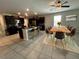 Open-concept kitchen and dining area features dark cabinets, stainless appliances, island seating, and a stylish dining set at 12957 Wildflower Meadow Dr, Riverview, FL 33579