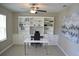 Bright office space with built-in shelving, sleek white desk, and contemporary decor provides an ideal work-from-home environment at 12957 Wildflower Meadow Dr, Riverview, FL 33579