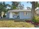 Quaint single-story home featuring a cozy front yard with mature trees and a lovely entryway at 1300 37Th S St, St Petersburg, FL 33711