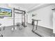 Home gym area showcasing a treadmill, power rack, weights, and a mounted television for entertainment at 13122 Prestwick Dr, Riverview, FL 33579