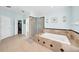 Luxurious main bathroom with soaking tub, glass-enclosed shower, neutral tile, and modern fixtures, creating a spa-like retreat at 13122 Prestwick Dr, Riverview, FL 33579