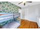 Stylish bedroom with an accent wall featuring playful leaf-themed wallpaper and hardwood floors at 138 17Th N Ave, St Petersburg, FL 33704