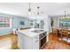 Open kitchen features a white center island with a cooktop, stainless steel oven, and modern pendant lighting at 138 17Th N Ave, St Petersburg, FL 33704