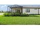 Lush backyard with manicured lawn, landscaping, and a screened-in patio on the home's exterior at 14221 Eagle Branch Dr, Nokomis, FL 34275