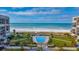Stunning aerial view of the community pool, beach access, and ocean at 1430 Gulf Blvd # 309, Clearwater Beach, FL 33767