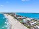 Aerial view of beachfront condos on a sunny day featuring clear blue water and sandy shoreline at 1430 Gulf Blvd # 309, Clearwater Beach, FL 33767