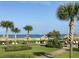 Beautiful beach access with palm trees, tiki hut umbrellas, and lounge seating at 1430 Gulf Blvd # 309, Clearwater Beach, FL 33767