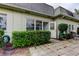 Backyard view of the home with manicured shrubs, paver patio, and tidy yard space at 1466 Normandy Park Dr # 4, Clearwater, FL 33756