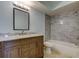 This bathroom features a vanity, toilet, and shower with updated gray tile surround at 1466 Normandy Park Dr # 4, Clearwater, FL 33756