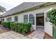 Exterior home view with manicured hedges, paver patio, and open access to the home's interior at 1466 Normandy Park Dr # 4, Clearwater, FL 33756