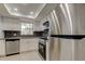 Modern kitchen with stainless steel appliances, granite countertops, subway tile backsplash, and sleek white cabinetry at 1466 Normandy Park Dr # 4, Clearwater, FL 33756