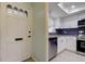 Bright kitchen with stainless appliances, granite countertops, dark backsplash, and white cabinets by a front door at 1466 Normandy Park Dr # 4, Clearwater, FL 33756