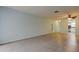 Another angle of the living room, features tile flooring, neutral walls, and smooth transitions to kitchen and hallway at 1466 Normandy Park Dr # 4, Clearwater, FL 33756