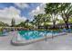 Community pool featuring lounge chairs, manicured landscaping, and clear blue water on a sunny day at 1466 Normandy Park Dr # 4, Clearwater, FL 33756