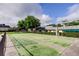 Community shuffleboard courts, benches, and meticulously trimmed hedges under a blue sky with puffy clouds at 1466 Normandy Park Dr # 4, Clearwater, FL 33756