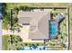 Aerial view of a home featuring a screened-in pool, fenced yard, patio, and well-maintained landscaping at 151 Harrisburg St, Port Charlotte, FL 33954