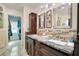 Bathroom featuring a double sink vanity with granite counters and decorative mirrors at 151 Harrisburg St, Port Charlotte, FL 33954