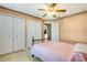 Bedroom with two closets, ceiling fan, tiled floors, and wooden bed frame at 151 Harrisburg St, Port Charlotte, FL 33954