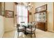 Bright dining room with glass table, four chairs, chandelier, and dark wood cabinet with glass doors at 151 Harrisburg St, Port Charlotte, FL 33954