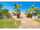 Charming home featuring a well-manicured lawn, tropical palm trees, and a decorative stone walkway at 151 Harrisburg St, Port Charlotte, FL 33954