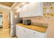The kitchen has updated appliances, stainless steel refrigerator, and ample counter space at 151 Harrisburg St, Port Charlotte, FL 33954