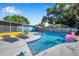 Inviting backyard pool with ample lounge space, complete with a hot tub and fun flamingo float at 1571 Belleair Rd, Clearwater, FL 33756