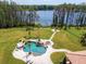 Aerial view showcasing a beautiful pool, lake, and fire pit, perfect for outdoor entertaining at 17221 Breeders Cup Dr, Odessa, FL 33556