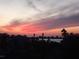 Scenic view of the water with palm trees and buildings silhouetted against a colorful sunset sky at 1860 N Fort Harrison Ave # 301, Clearwater, FL 33755