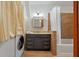 Well-appointed bathroom with a vanity, bathtub/shower combo, and convenient laundry area at 2047 Indigo Dr, Clearwater, FL 33763