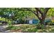 Charming home with lush landscaping and a large shade tree, offering curb appeal and a welcoming atmosphere at 2047 Indigo Dr, Clearwater, FL 33763