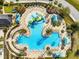 Aerial view showcasing the community pool with water slides, seating areas, and lush landscaping at 22229 Storybook Cabin Way, Land O Lakes, FL 34637