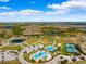 Wide aerial shot of the community, highlighting the pools, tennis courts, and expansive green spaces at 22229 Storybook Cabin Way, Land O Lakes, FL 34637
