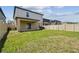 A backyard view showing the lawn, fence, covered patio, and a grill at 22229 Storybook Cabin Way, Land O Lakes, FL 34637