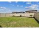 Fenced backyard with green grass and three palm trees along the back fence at 22229 Storybook Cabin Way, Land O Lakes, FL 34637